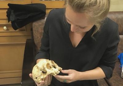 Photo of Paige Madison with the skull of Homo floresiensis