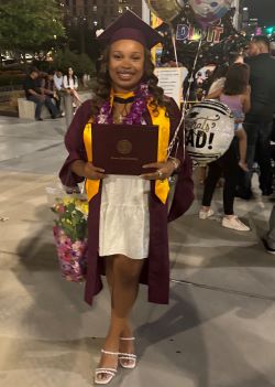 Photo of Ilani Higgins holding her diploma