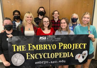 EP students holding an embryo project encyclopedia banner