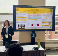 Photo of Christina Stewart presenting her eposter at AAAS 2025